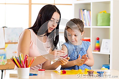 Kid creativity. Child girl with her mother sculpting from play clay Stock Photo