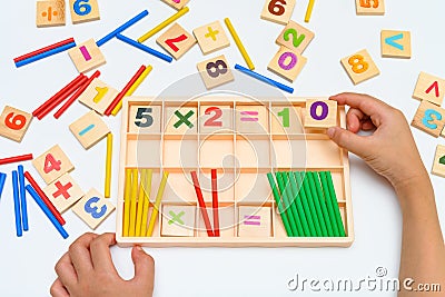 Kid doing multiplication equation using counting rod Stock Photo