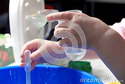 Kid doing scientific experiment at home with liquids holding a test tube and a pasteur pipette. Hands close-up, the concept of Stock Photo