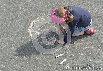 The kid draws mom on asphalt on a summer day. Stock Photo