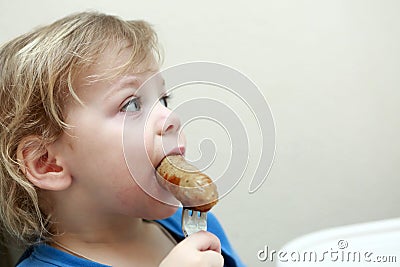 Kid eating sausage Stock Photo