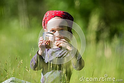 Kid eating wild strawberries in a green meadow. Healthy organic nature gifts, vitamins Stock Photo