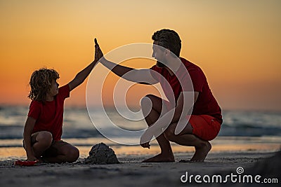 Kid and father building sandcastle. Father and son playing on beach. Friendly family. Father and son playing in the sand Stock Photo