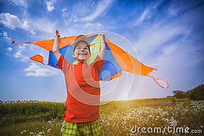 Kid flies a kite into the blue sky Stock Photo
