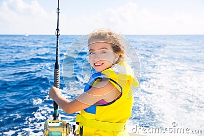 Kid girl boat fishing trolling rod reel and yellow life jacket Stock Photo