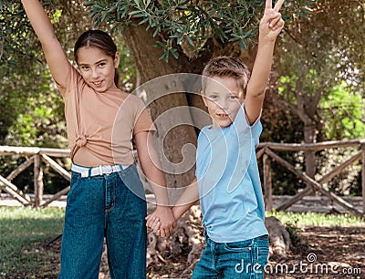 Kid girl and boy showing V gest outdoor Stock Photo