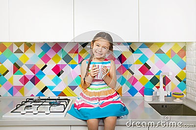 Kid girl having fun at kitchen. Colorful interior Stock Photo