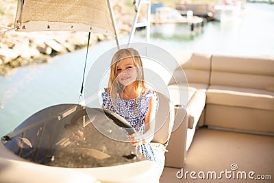 Kid girl at helm of boat on pier. travel on water. Stock Photo