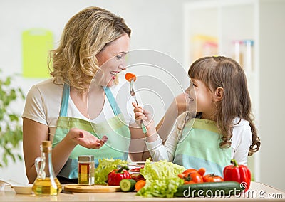 Kid girl and mother eating healthy food vegetables Stock Photo