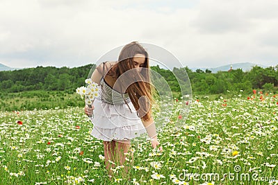 Kid girl picking flowers on the meadow Stock Photo