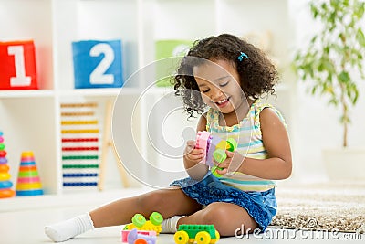 Kid girl playing toys at kindergarten room Stock Photo