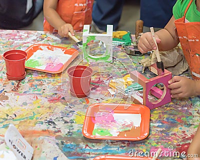 Kid hands painting craft at building workshop in local hardware store in Texas, USA Stock Photo