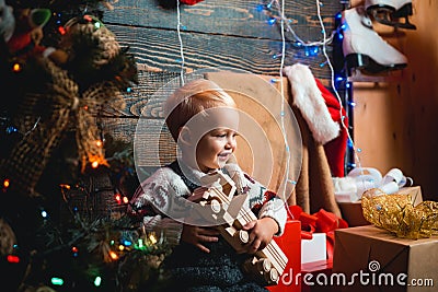 Kid having fun near Christmas tree indoors. hildren gift. Christmas kids. Christmas tree decoration. Winter kids. Stock Photo