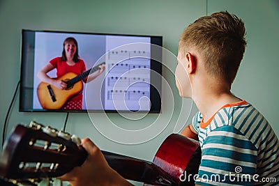 Kid having guitar lesson online, distant learning Stock Photo