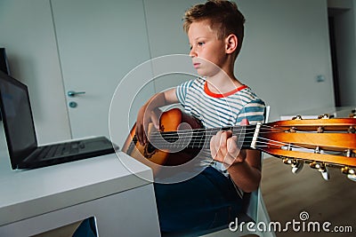 Kid having guitar lesson online, remote music class Stock Photo