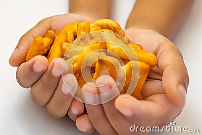 Kid holding Abc biscuits alphabet yellow background. stock photo XYZ Stock Photo