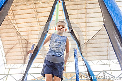 A kid jumping on a trampoline. Happy boy plays outdoors jumping high on trampoline Stock Photo