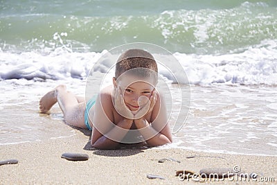 Kid laying on beach Stock Photo