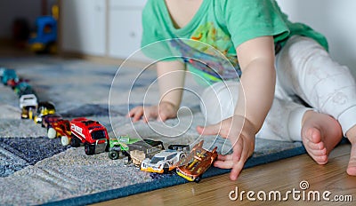 Kid lining up toys on the floor Stock Photo