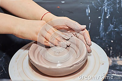 Modeling of clay on a potter`s wheel In the pottery workshop Stock Photo