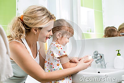 Kid with mom washing hands Stock Photo