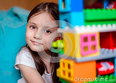 Kid is playing with Colorful lego bloks in her room. Close-up. Stock Photo