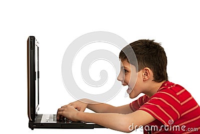 Kid is playing computer game on the laptop Stock Photo