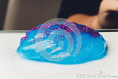 Kid Playing Hand Made Toy Called Slime Alien drool Shell mussel. Stock Photo