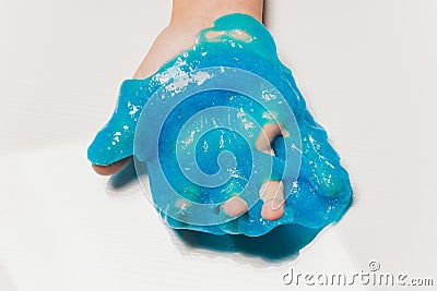 Kid Playing Hand Made Toy Called Slime Alien drool Shell mussel. Stock Photo