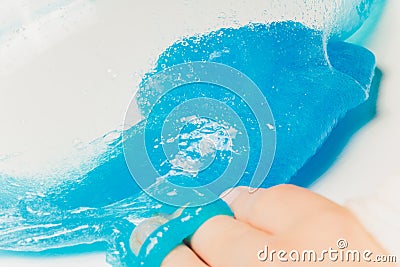 Kid Playing Hand Made Toy Called Slime Alien drool Shell mussel. Stock Photo