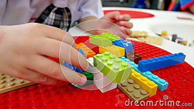 A kid is playing toys. Building blocks and bricks toys. Stock Photo