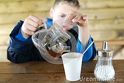 Kid pouring herbal tea Stock Photo