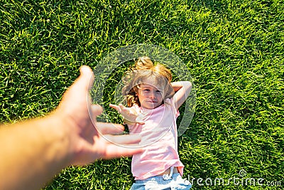 Kid pull father hand. Follow me, hand-in-hand walking on bright sunny day. Child holding man& x27;s hand and leading him on Stock Photo