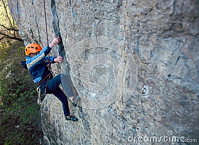 Kid rock climber climbs the cliff. Stock Photo