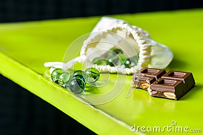 A kid's bag with glass marbles a piece of chocolate tablet Stock Photo