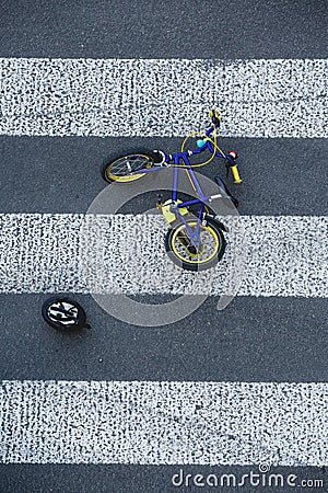 Kid`s bike lying on the road after car accident Stock Photo