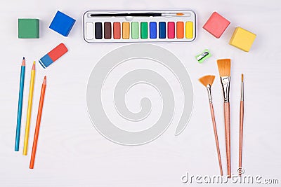 Kid`s desk with colorful pencils, brushes and watercolors, top view Stock Photo