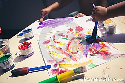 kid's drawing, painting with a brush and hands with color temperas on paper Stock Photo