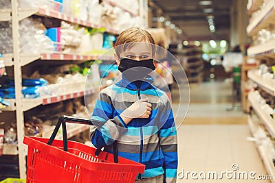 Kid with shopping basket in supermarket. Child wears protected mask in shop Stock Photo