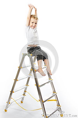 Kid sitting on top of stepladder, hands raise up. Stock Photo