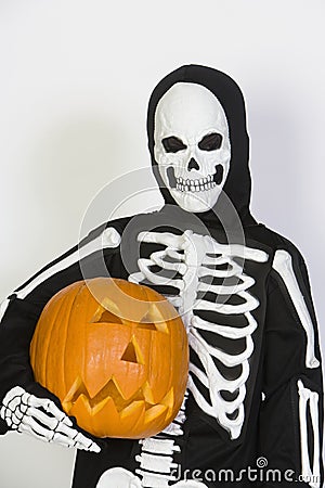 Kid In Skeleton Costume Holding Jack-O-Lantern Stock Photo