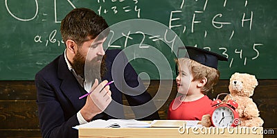 Kid studying with teacher. Father teaches son, discuss, explain. Education concept. Teacher in formal wear and pupil in Stock Photo