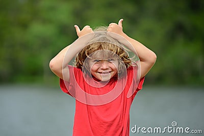 Kid thumbs-up. Child boy approves. Portrait of smiling little boy showing thumbs up. Stock Photo