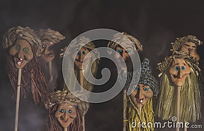 Kid toys witch heads on sticks. With fog and smoke on dark pastel background Stock Photo