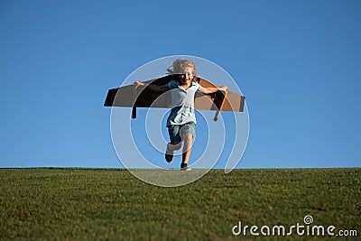 Kid traveller with backpack wings. Child playing pilot aviator and dreams outdoors in park. Young boy pilot against a Stock Photo