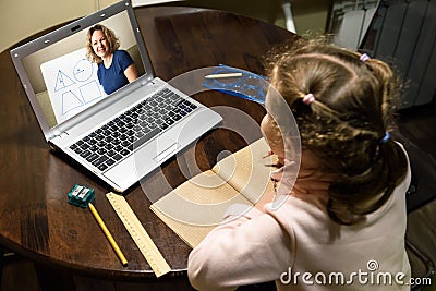 Kid virtual learning with teacher by laptop, tutor teaches preschool child during quarantine due to coronavirus Stock Photo