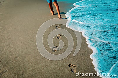 Kid walking on beach leaving footprint in sand Stock Photo