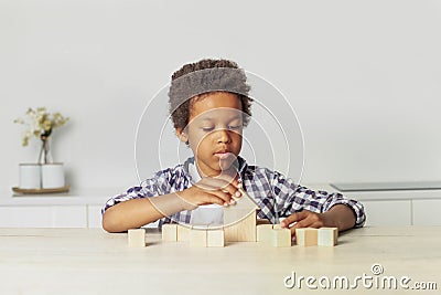 Kid and wooden house and blocks. Child playing at home Stock Photo