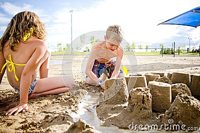 Kids on a beach with sand castle Stock Photo