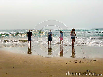 Kids at beach watching waves Stock Photo